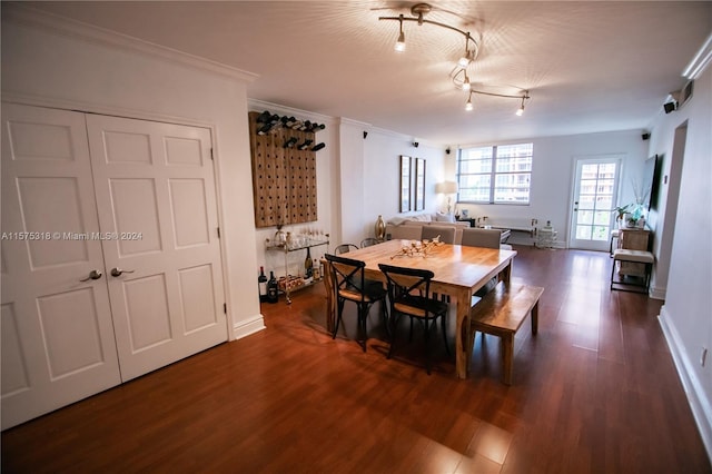 dining room with ornamental molding and dark hardwood / wood-style flooring