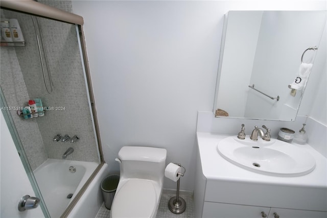 full bathroom featuring tile flooring, large vanity, toilet, and bath / shower combo with glass door