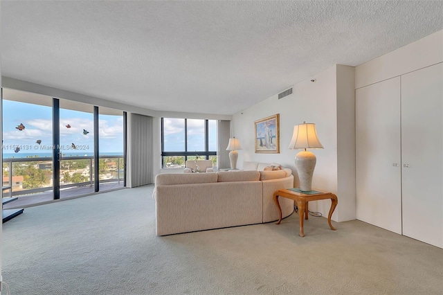 carpeted living room featuring a wall of windows and a textured ceiling