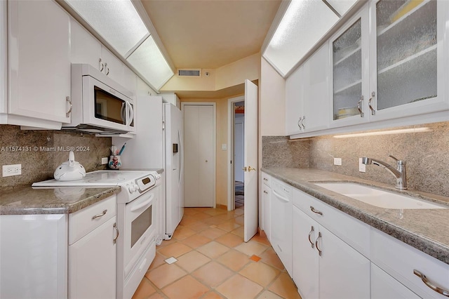 kitchen with white appliances, tasteful backsplash, sink, white cabinetry, and light tile patterned floors