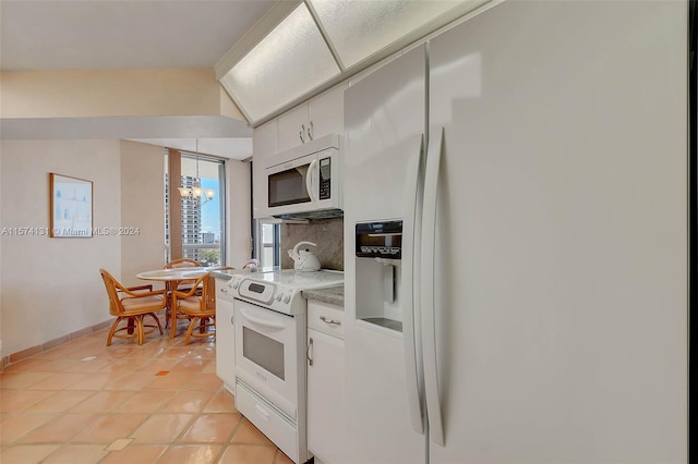 kitchen with white cabinetry, a chandelier, light tile patterned flooring, light stone counters, and white appliances