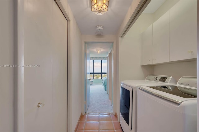 laundry area with cabinets, washer and dryer, and light carpet