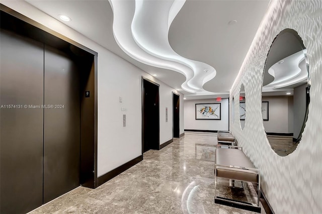 hallway featuring tile walls and elevator