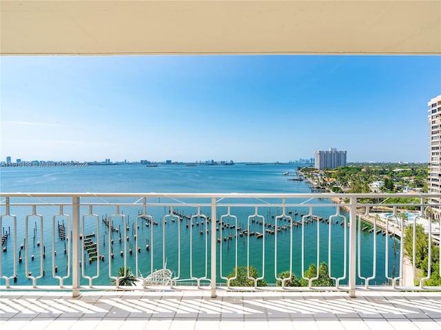 balcony featuring a water view and a city view