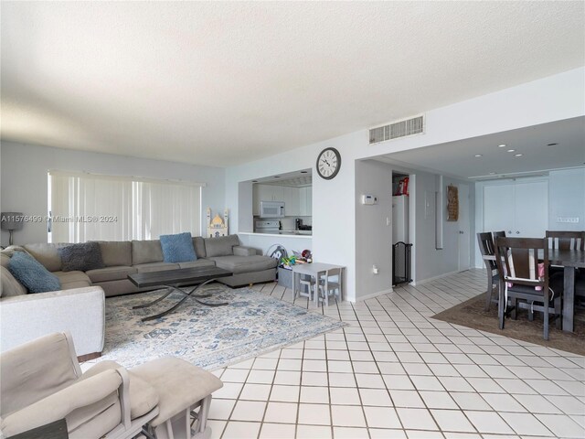 living room with a textured ceiling and light tile patterned floors