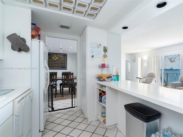 kitchen featuring open shelves, light tile patterned floors, light countertops, visible vents, and white appliances