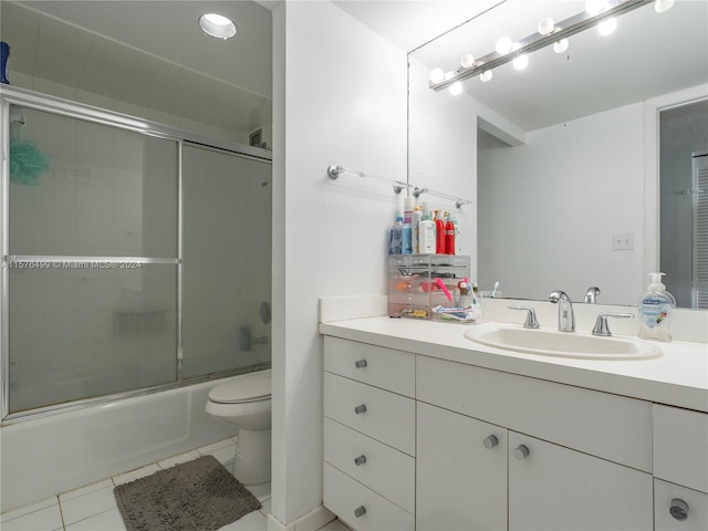 full bath with tile patterned floors, vanity, toilet, and bath / shower combo with glass door