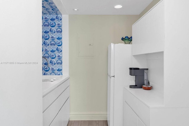 bathroom with electric panel, vanity, and hardwood / wood-style flooring