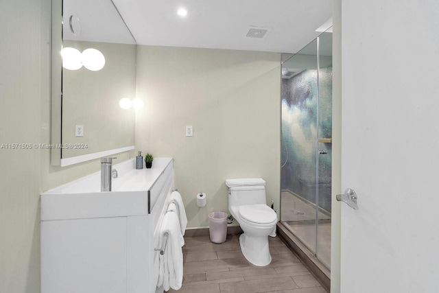 bathroom featuring an enclosed shower, vanity, toilet, and wood-type flooring