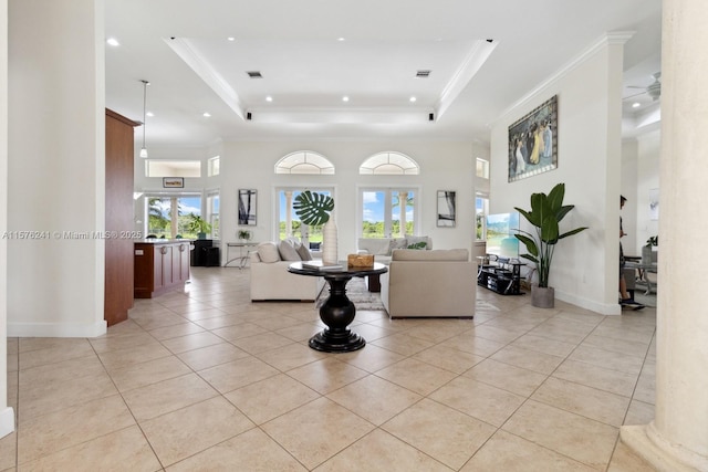 living room with plenty of natural light, a raised ceiling, and light tile patterned floors