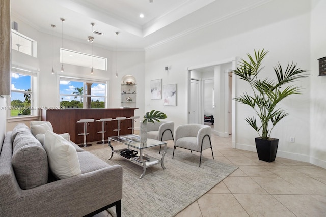 living room with a tray ceiling, crown molding, light tile patterned floors, and a high ceiling