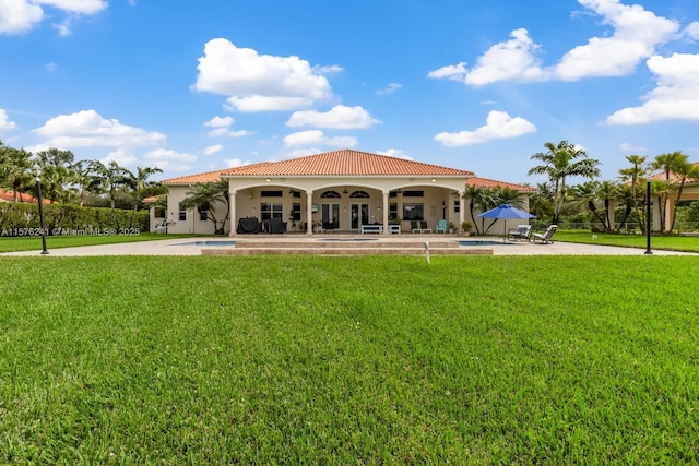 back of house featuring a fenced in pool, a patio area, and a lawn