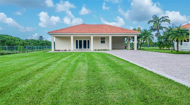 back of house featuring a lawn, french doors, and a carport