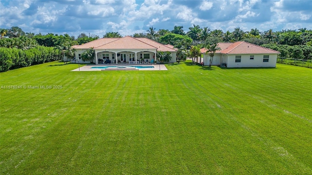 rear view of house featuring a lawn and a patio area