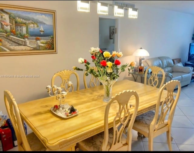 kitchen featuring stove, white cabinets, white refrigerator, and light tile patterned floors