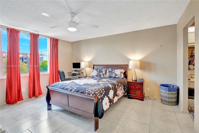 bedroom with a textured ceiling, ceiling fan, and tile floors