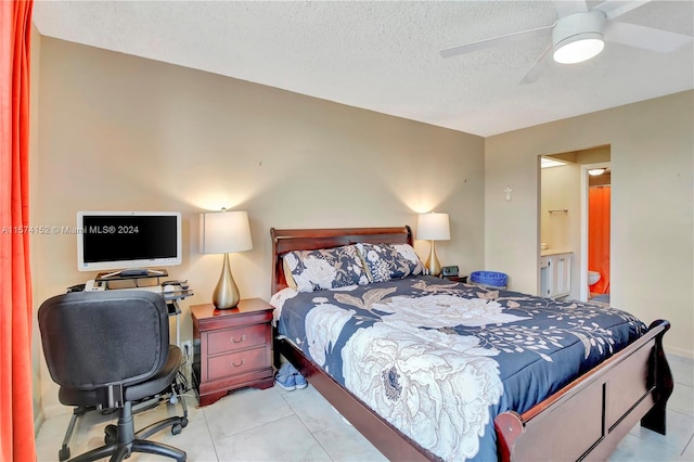 bedroom with a textured ceiling, connected bathroom, ceiling fan, and light tile floors