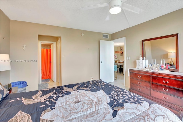 tiled bedroom featuring ceiling fan and a textured ceiling