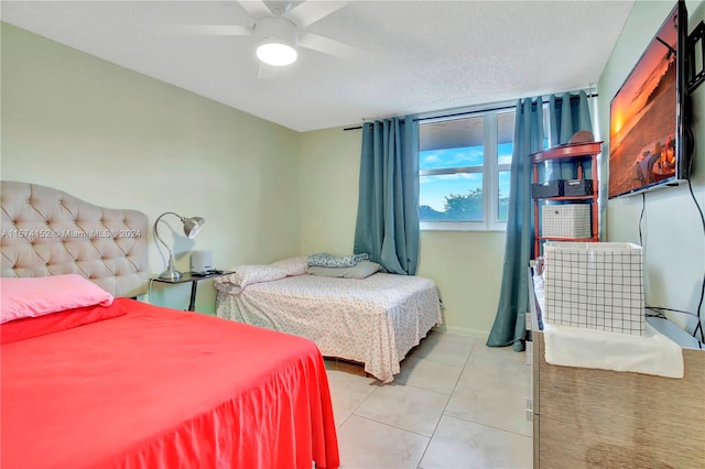 tiled bedroom featuring ceiling fan and a textured ceiling