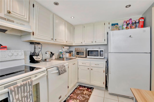 kitchen featuring white cabinets, white appliances, sink, and light tile floors