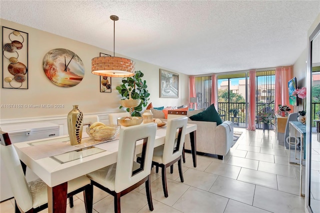 dining space featuring floor to ceiling windows, a textured ceiling, and tile floors