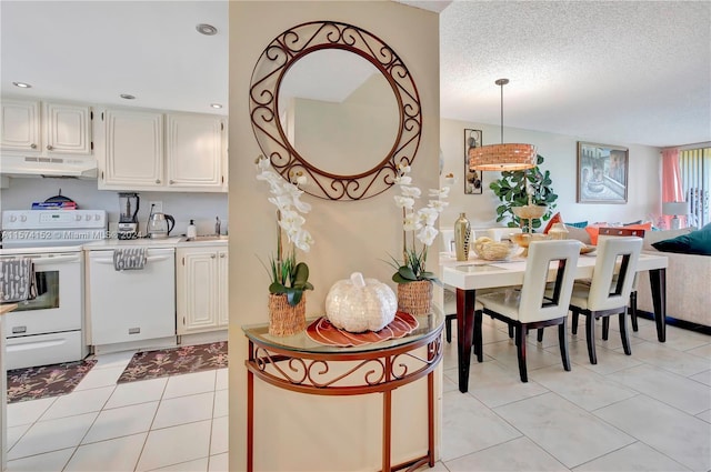 kitchen featuring sink, a textured ceiling, light tile flooring, and electric stove