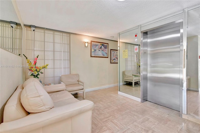 living room with elevator and a textured ceiling