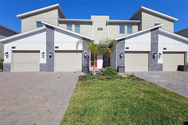 modern home featuring a garage and a front lawn