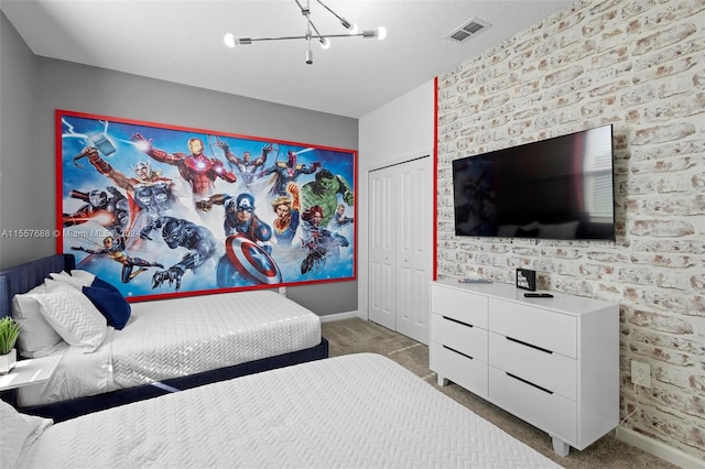 carpeted bedroom featuring brick wall, an inviting chandelier, and a closet