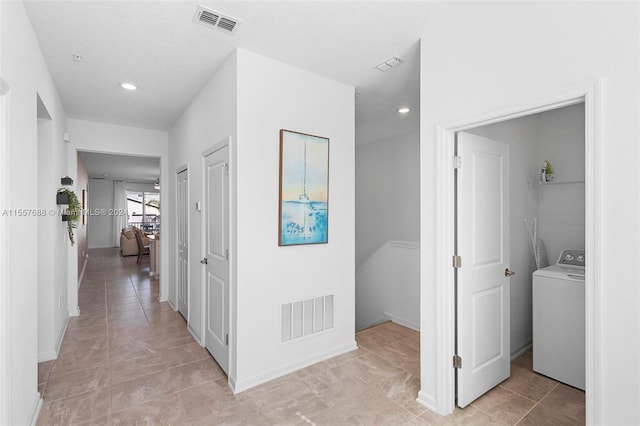 corridor featuring light tile floors and washer / clothes dryer