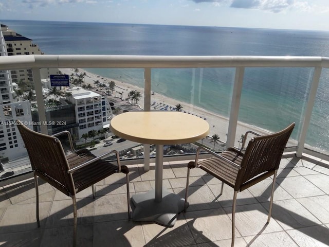 balcony featuring a water view and a beach view