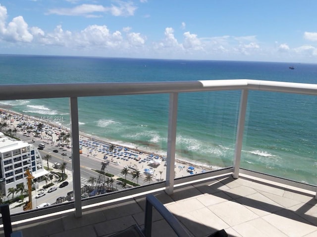 balcony featuring a view of the beach and a water view