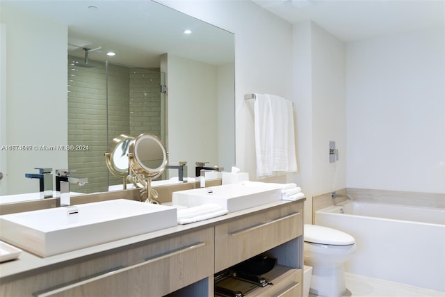 bathroom with a bath, large vanity, toilet, and double sink