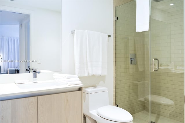 bathroom featuring an enclosed shower, vanity, and toilet