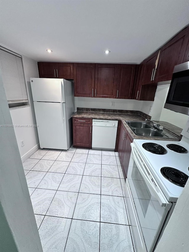 kitchen featuring light tile patterned flooring, white appliances, and sink