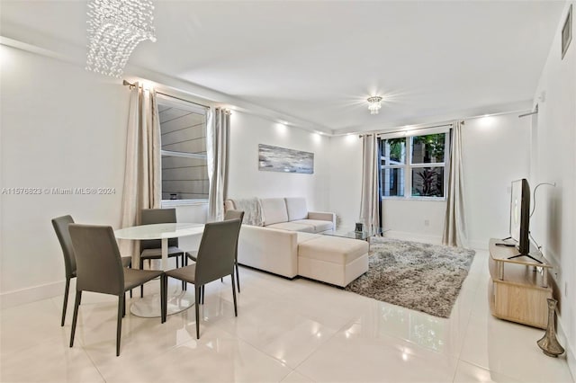 tiled living room with a notable chandelier