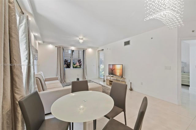 dining space featuring light tile floors and an inviting chandelier