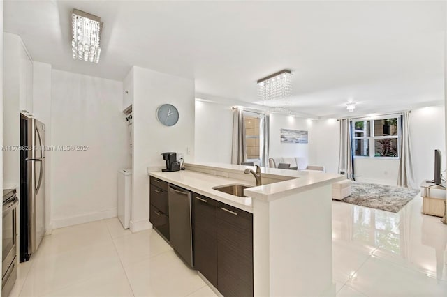 kitchen featuring sink, appliances with stainless steel finishes, kitchen peninsula, and light tile floors