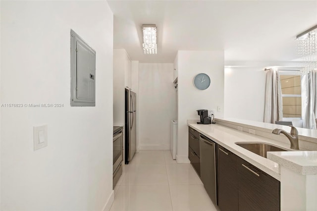 kitchen with appliances with stainless steel finishes, light tile floors, sink, and dark brown cabinetry