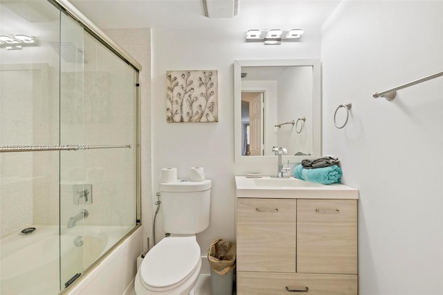 full bathroom featuring toilet, oversized vanity, and combined bath / shower with glass door