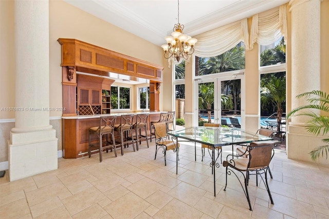 dining space featuring decorative columns, light tile flooring, and an inviting chandelier