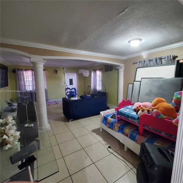 bedroom with a textured ceiling, crown molding, tile floors, and decorative columns