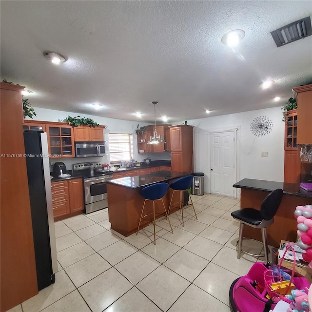 kitchen featuring a center island, light tile flooring, and appliances with stainless steel finishes