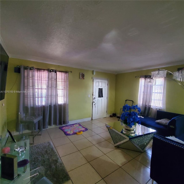 living room featuring a healthy amount of sunlight, tile flooring, crown molding, and a textured ceiling