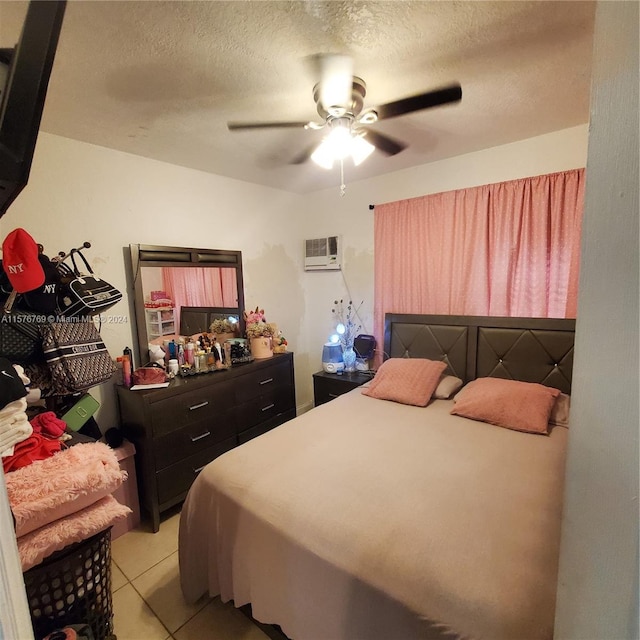 tiled bedroom featuring ceiling fan, a textured ceiling, and a wall mounted air conditioner