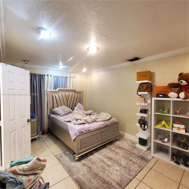 tiled bedroom featuring ornamental molding and a textured ceiling