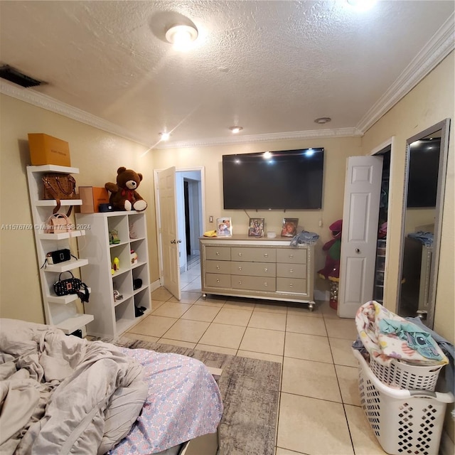 bedroom with a textured ceiling, ornamental molding, and light tile flooring