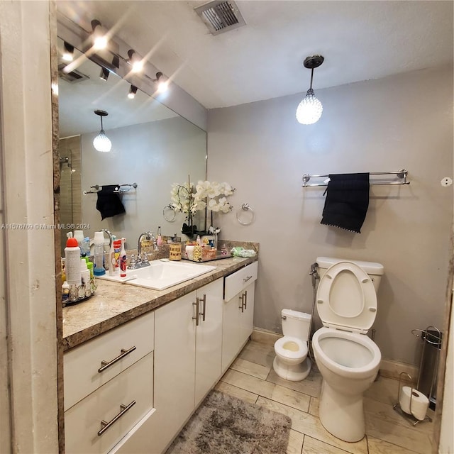 bathroom featuring tile flooring, oversized vanity, toilet, and walk in shower