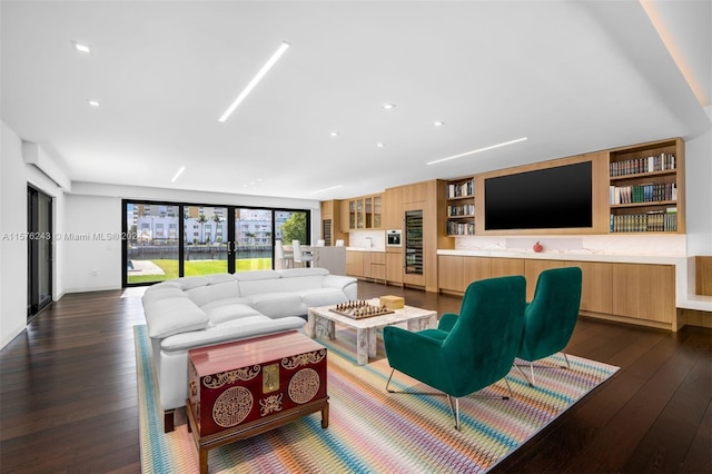 living area with dark wood-style floors and built in shelves