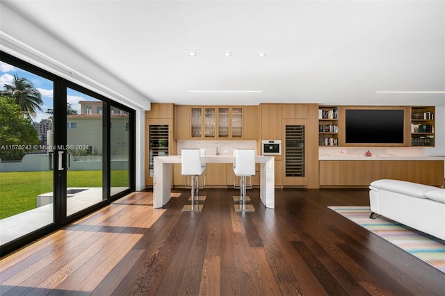 kitchen with dark hardwood / wood-style floors, a breakfast bar, and tasteful backsplash